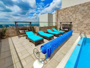 内罗毕Elite Residence 1 bedroom Westlands with views, gym &pool的一个带蓝色椅子的游泳池和一个游泳池