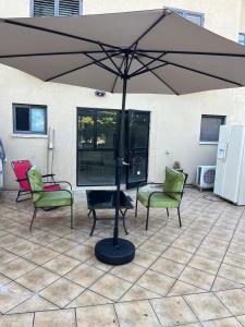Gannot Hadarסוויטה במושב פסטורלי רומנטי ושקט的露台上的大遮阳伞,配有桌椅