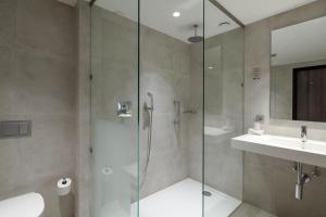 亨厄洛亨厄洛凡德瓦克酒店的一间带玻璃淋浴和水槽的浴室