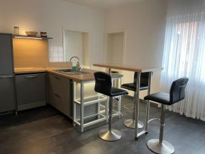 诺伊斯M&M Apartment Düsseldorf的厨房配有水槽和2个吧台凳