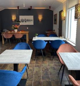 德科赫DuinHotel Texel的一间配备有桌子和蓝色椅子的用餐室