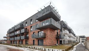 波兹南Poznań Airport Comfy Apartment的一面设有一面阳台的砖砌建筑