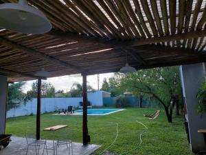 富内斯Casa en Funes. Pileta, Parrilla & Parque.的一个带木制凉亭和游泳池的庭院