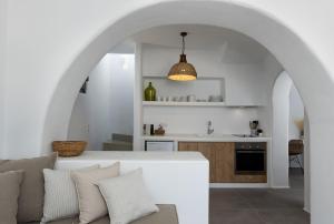 布拉卡Archon Seaside Retreat的厨房以及带沙发和拱门的起居室。