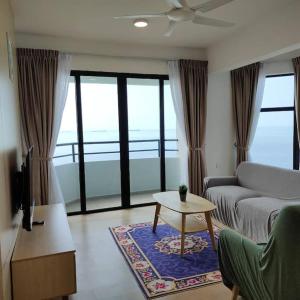 Mutiara Melaka Beach Resort by Ally的客厅配有沙发和桌子