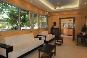 雅典IKAROS Hotel ELLINIKO的客厅配有白色的沙发和窗户。