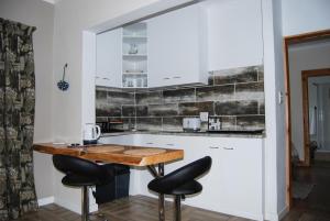 霍维克Urban Bush Lodge的厨房配有木桌和黑色凳子