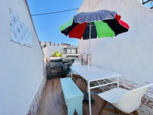 费拉古多Central Cozy Home Ferragudo的一张桌子,上面有五颜六色的雨伞