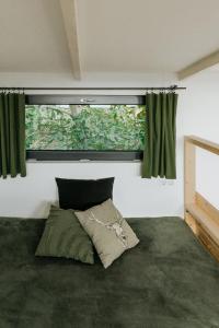 泽拜盖尼Hegyi Pihenő的一间卧室设有床铺和一个带绿色窗帘的窗户。