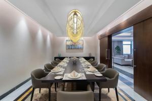 利雅德Movenpick Hotel and Residences Riyadh的一间带长桌和椅子的用餐室