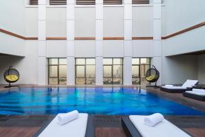 利雅德Movenpick Hotel and Residences Riyadh的大楼里一个蓝色的大泳池
