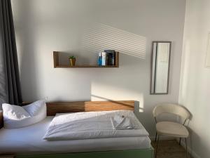 普特布斯Circus Hostal Putbus的一间卧室配有一张带椅子和镜子的床
