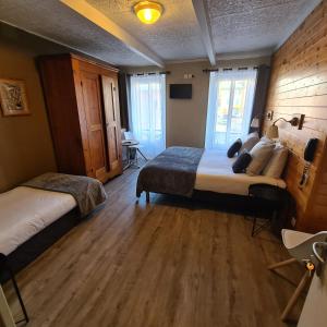 巴斯洛内特格兰德酒店的一间卧室设有两张床,铺有木地板