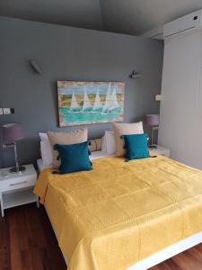 蓝海湾探索声望住宿加早餐旅馆的一间卧室配有一张带蓝色枕头的大型黄色床