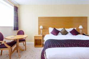 多切斯特George Albert Hotel & Spa的酒店客房配有一张床铺和一张桌子。