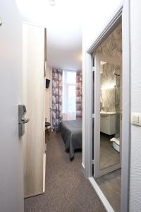 布鲁塞尔Hotel Derby MERODE的客房设有一张床和一间带镜子的浴室