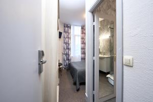 布鲁塞尔Hotel Derby MERODE的小房间设有一张床和一间浴室
