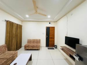 印多尔Home Escape 1BHK Apartment Near Bombay Hospital的带沙发和平面电视的客厅