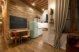 锡耶纳Al 24 Rosso的厨房配有桌子和砖墙上的黑板