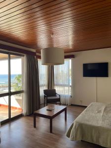 里韦拉布拉瓦Flag Hotel Madeira - Ribeira Brava的卧室配有1张床、1张桌子和1把椅子