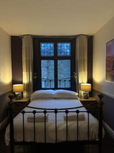 切斯特菲尔德The Old Poets Corner的一间卧室配有一张带两盏灯的床和一扇窗户。