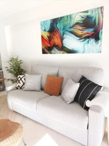 普拉加德阿罗Bounty apartment的客厅配有一张沙发,墙上挂有绘画作品