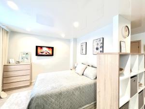 纳尔瓦Modern Charming Studio Narva Center的卧室配有一张床,墙上配有电视。