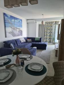 北马马亚-讷沃达里ALZ Beach Apartments in Alezzi Beach Resort的客厅配有蓝色的沙发和桌子