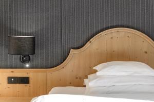 摩德纳迪-坎皮格里奥希尔米塔吉毕欧酒店的一间卧室配有一张带木制床头板的床