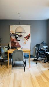 哥本哈根ApartmentInCopenhagen Apartment 1580的一间带桌椅和绘画的用餐室