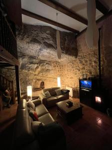 阿尔巴拉辛Casa De La Roca的带沙发和电视的客厅