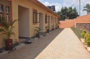 坎帕拉Malaika Furnished Apartments的砖砌的走道,旁边是种有盆栽植物的建筑