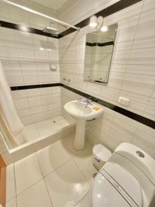 特鲁希略Jultom Inn Hotel & Suites的白色的浴室设有卫生间和水槽。