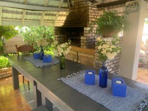 波罗瓜尼Bougain Villa BnB的一张长桌,上面有蓝色花瓶