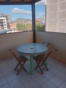 库斯科Posada de Mama的阳台配有一张绿色桌子和两把椅子