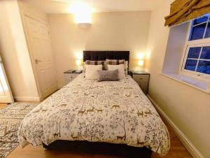 南特威奇Cosy Central Modern Apartment的一间卧室设有一张大床和两个窗户。