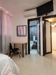圣多明各Aparta Hotel Drake Piantini的一间卧室配有书桌和桌椅