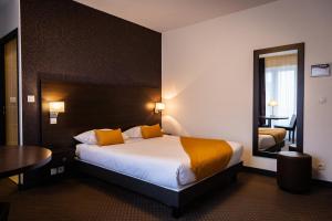 凯恩Hotel Astrid Caen centre的酒店客房配有床、桌子和镜子