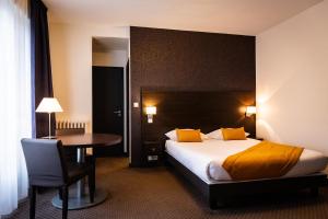 凯恩Hotel Astrid Caen centre的酒店客房配有一张床铺和一张桌子。