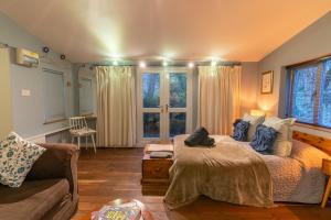巴斯Somerset Lodge, a secret hideaway的一间卧室配有一张床、一张沙发和窗户。