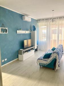 马达莱纳Appartamento Tizzy的一间卧室设有一张床和蓝色的墙壁