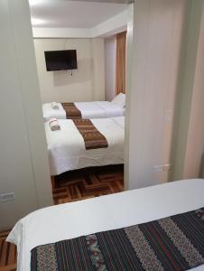 库斯科Posada de Mama的酒店客房,设有两张床和镜子