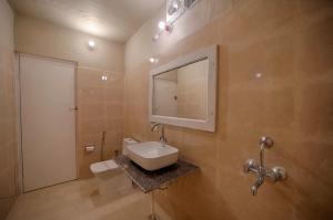 萨瓦伊马多普尔狩虎台酒店的一间带水槽、卫生间和镜子的浴室