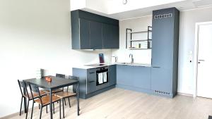 奥斯陆Brand new and modern apartment in Oslo center的厨房配有蓝色橱柜和桌椅