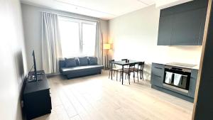 奥斯陆Brand new and modern apartment in Oslo center的厨房以及带桌子和沙发的客厅。