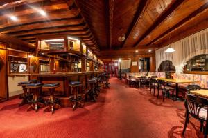 万丹斯Hotel Brunella的餐厅内带桌椅的酒吧
