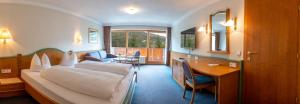 万丹斯Hotel Brunella的配有一张床和一张书桌的酒店客房