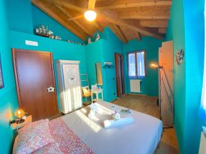 德尔维奥拉卡萨德尔波伊塔旅馆的一间拥有蓝色墙壁的卧室和一张带白色床单的床