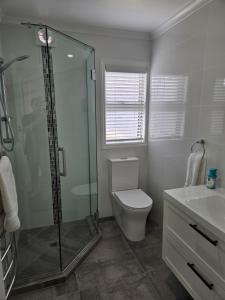 罗托鲁瓦Redwood Apartments的带淋浴、卫生间和盥洗盆的浴室