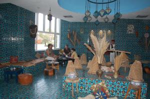 马赫迪耶Monarque El Fatimi Mahdia的一间拥有蓝色墙壁的房间,里面的人坐在里面
